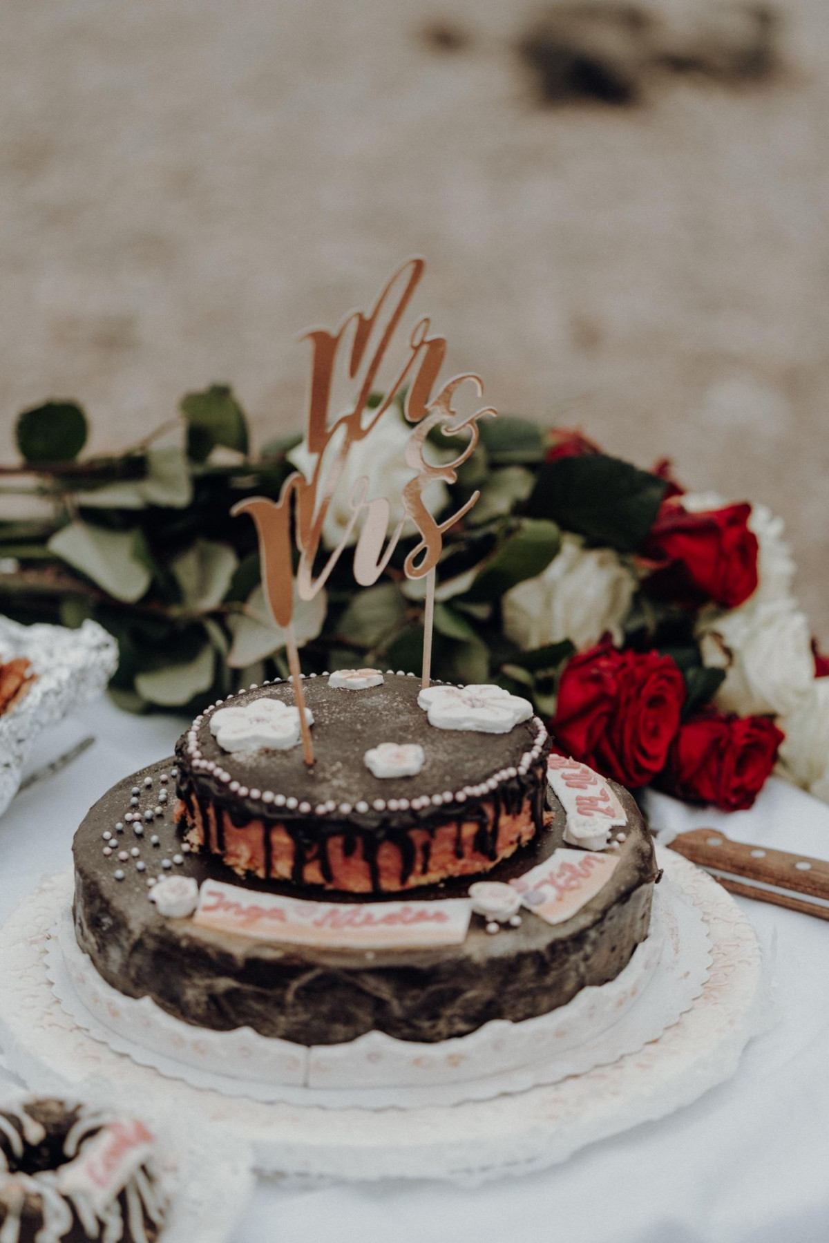Hochzeitstorte und Rosenstrauß auf Tisch