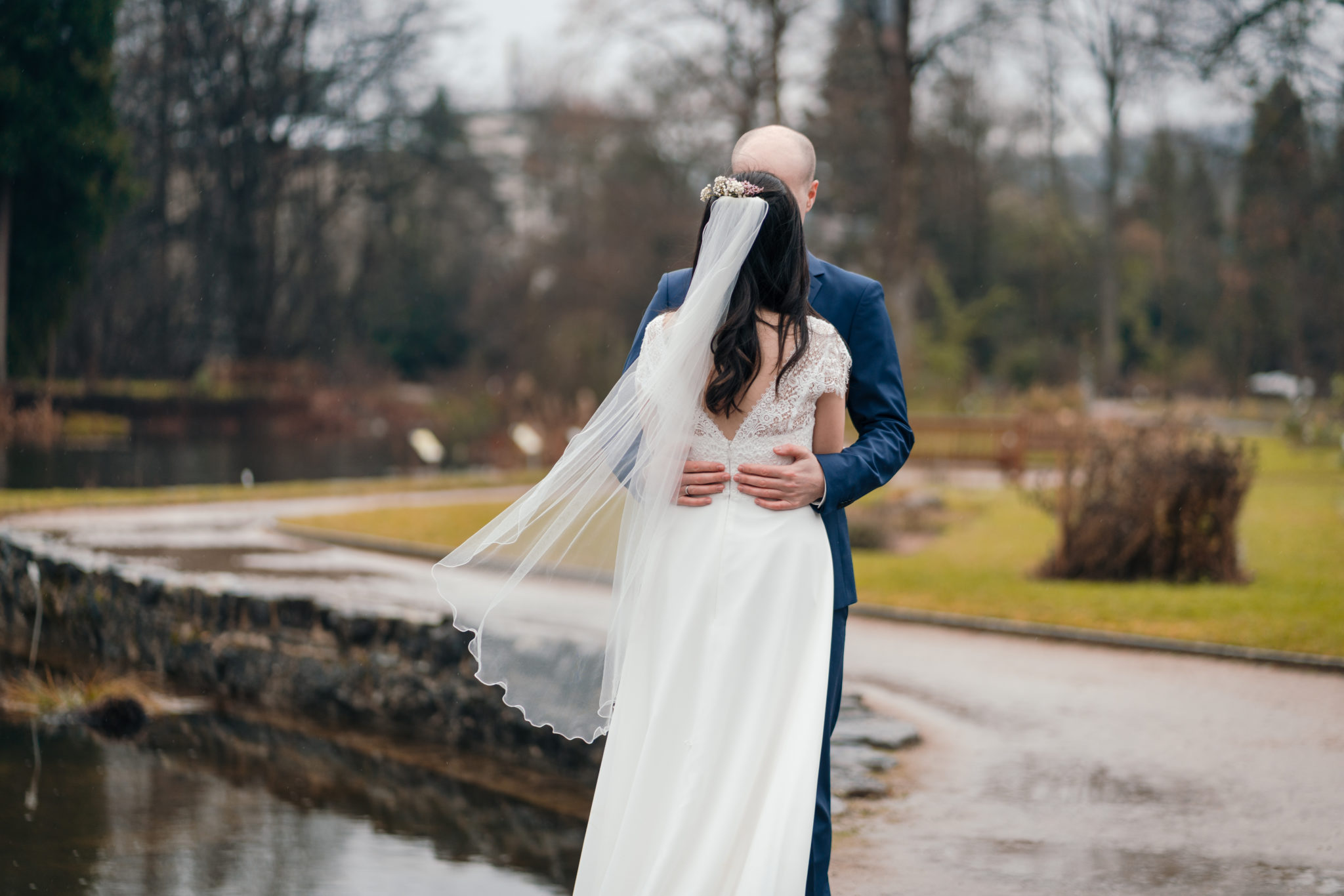 Bräutigam umarmt Braut in Schlossgarten