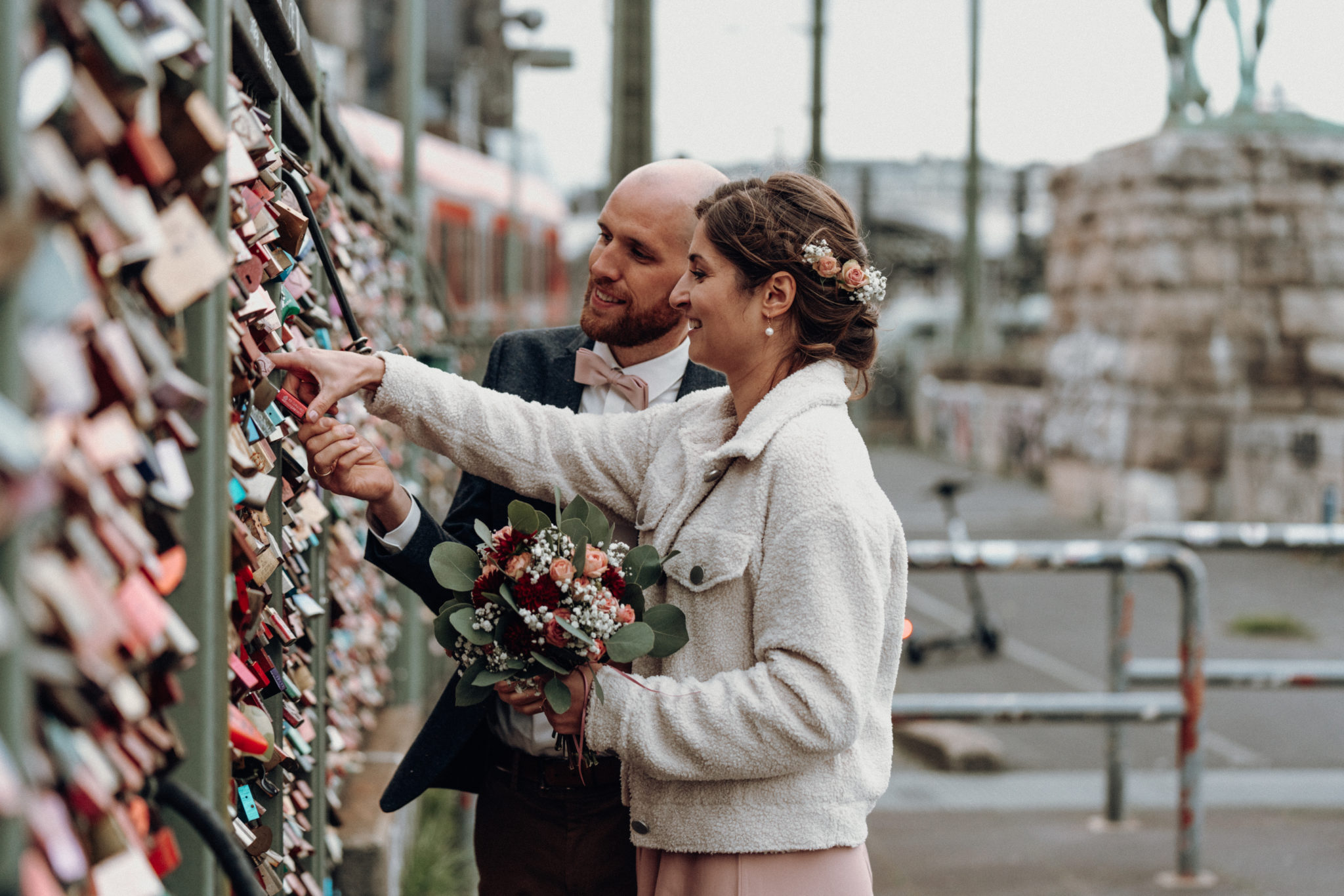 Hochzeitsshooting auf Hohenzollernbrücke, Paar macht Liebesschloss an Brücke