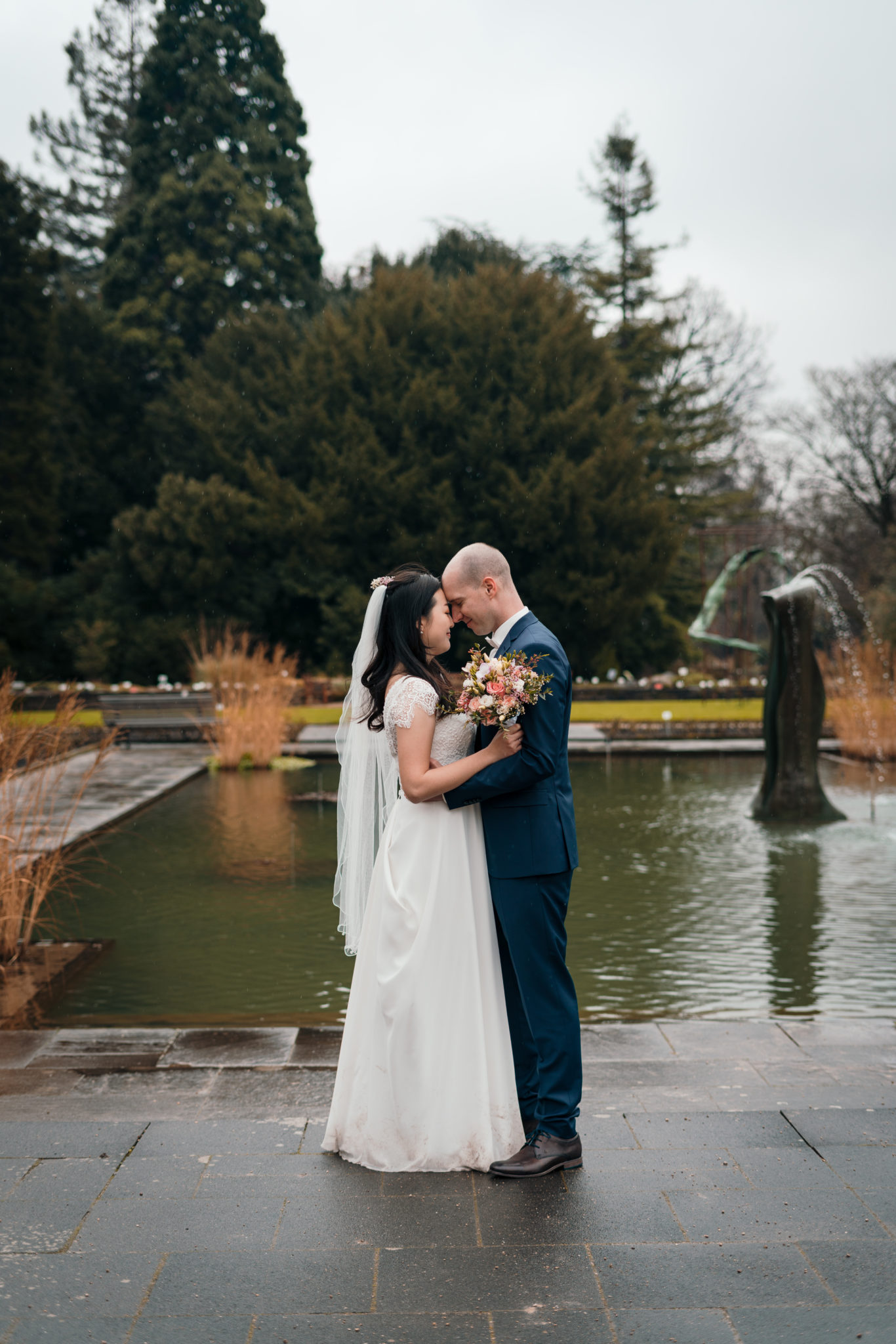 Paar steht Stirn an Stirn vor Teich des botanischen Gartens