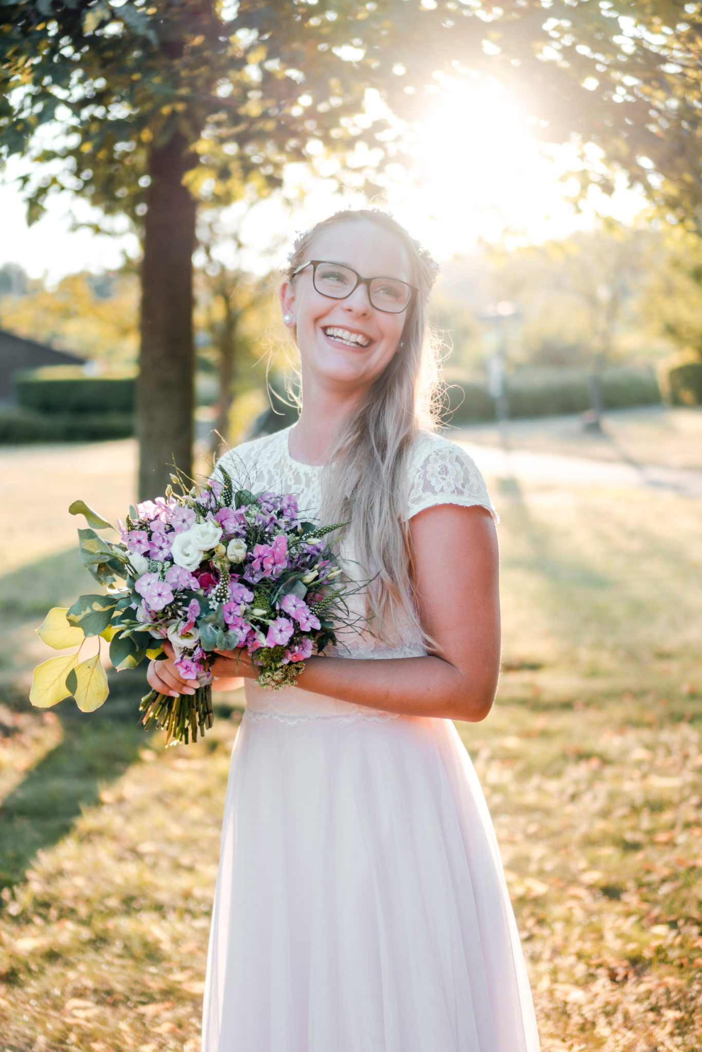 Lachende Braut bei Brautshooting in Kleingärten während Sonnenuntergang
