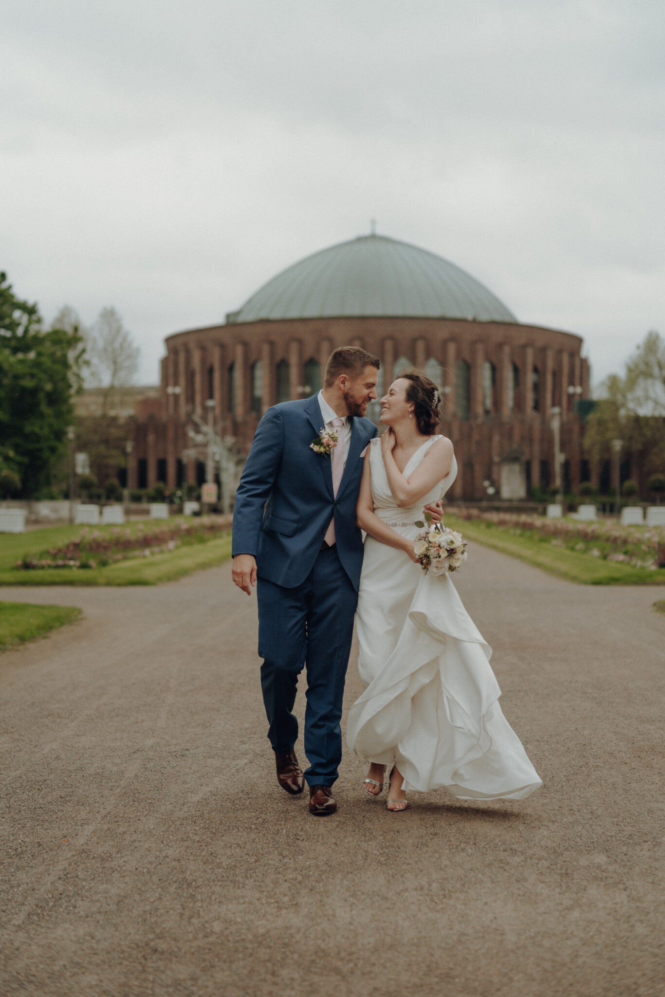 Brautpaar läuft lachend im Schlossgarten