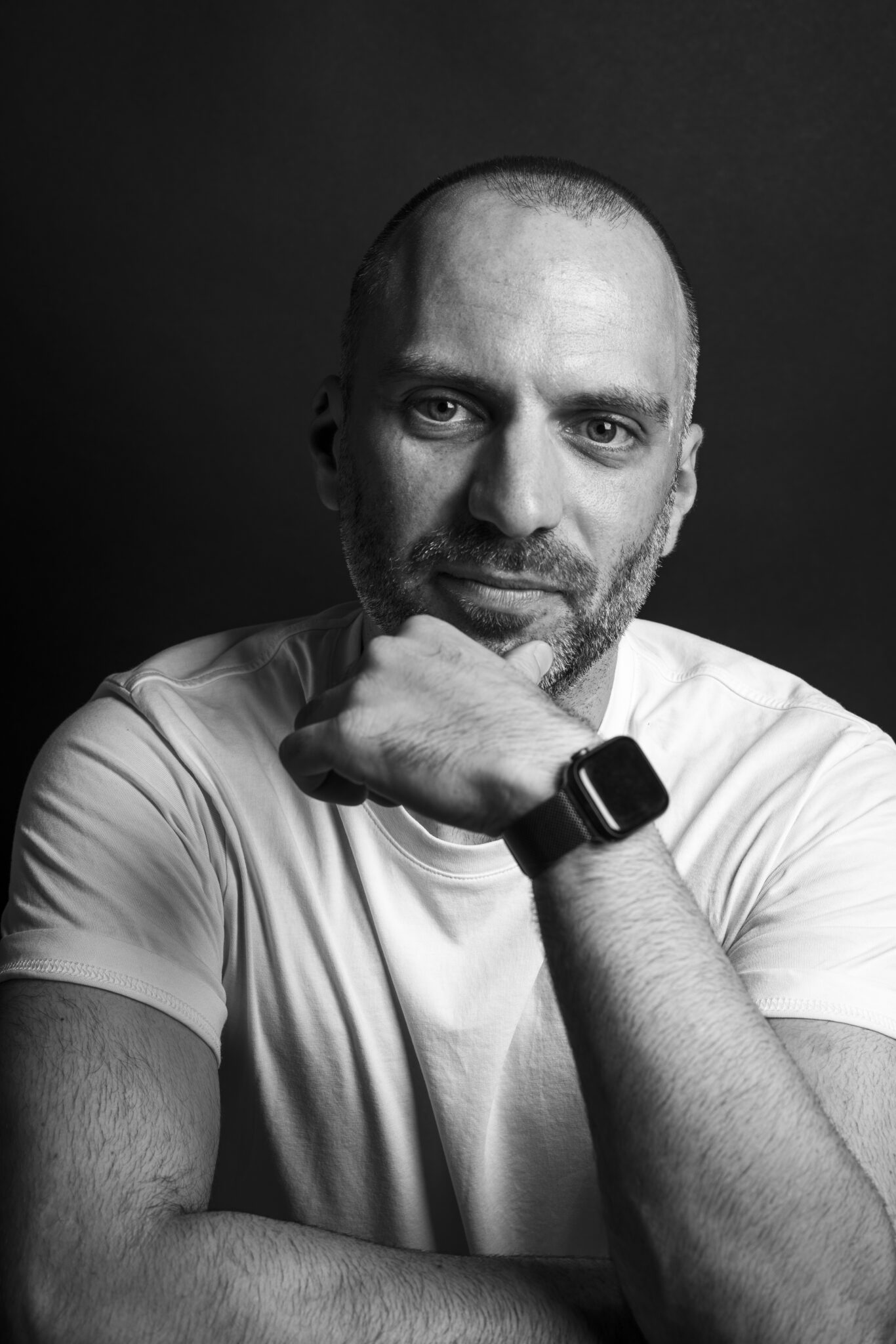 Schwarz Weiß Portraitfoto eines Mannes vor einfarbigem Studiohintegrund