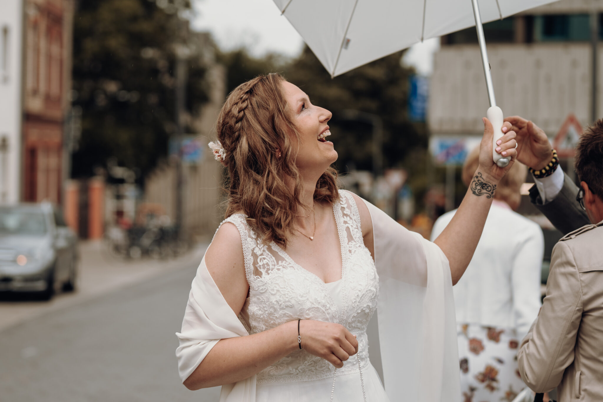 Braut lachend mit Regenschirm
