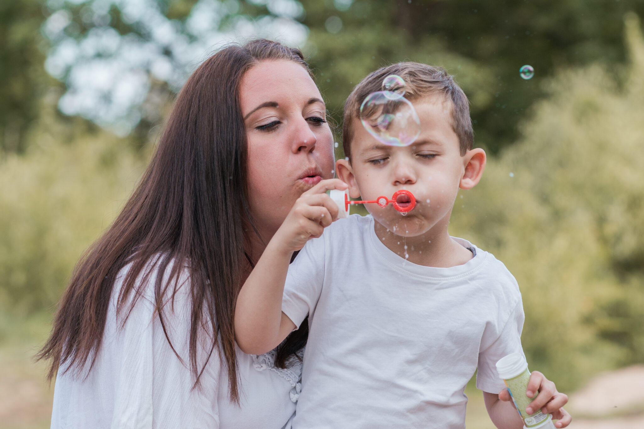 Familienfotoshooting mit Kleinkind, Sohn pustet in Seifenblasen