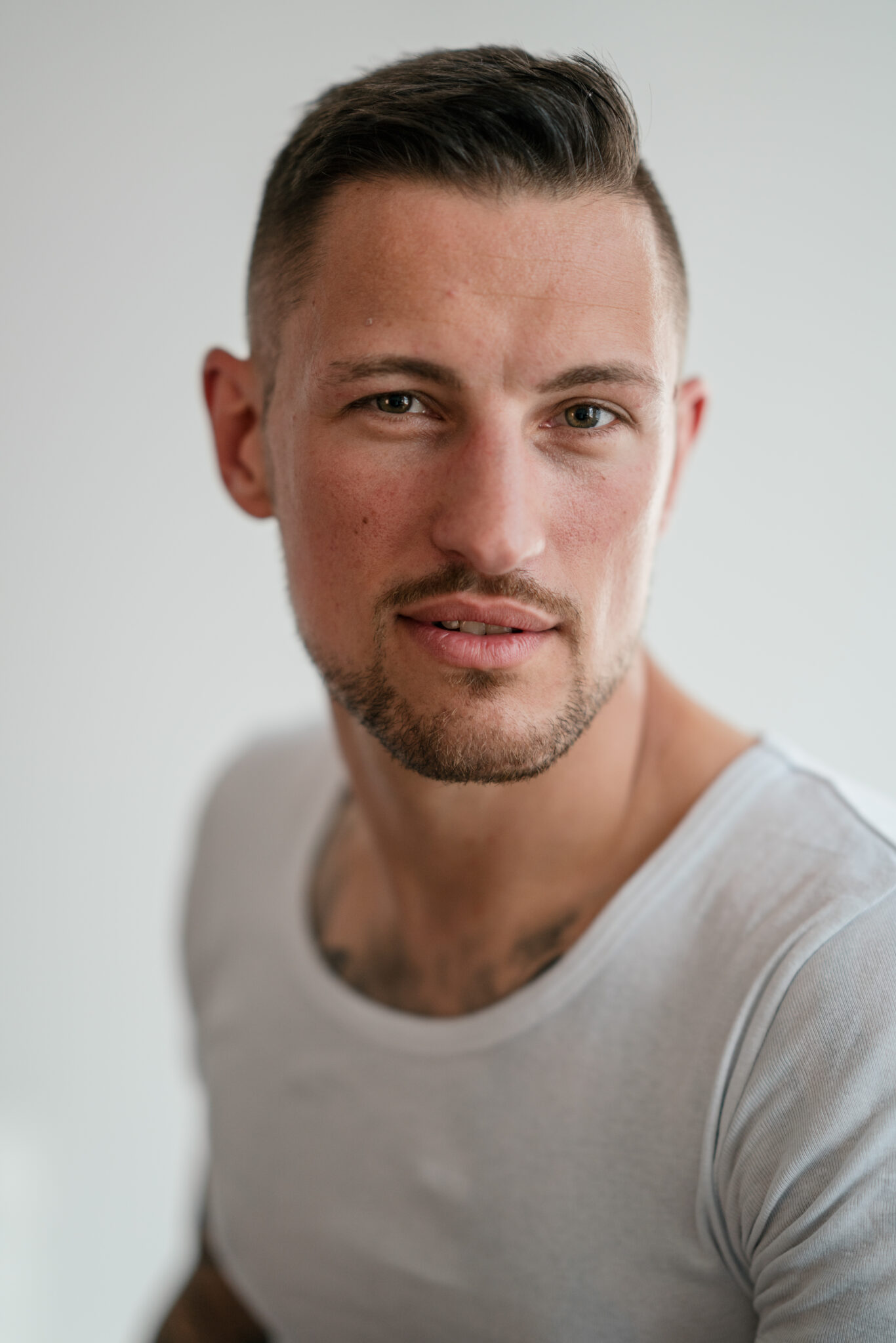Portrait eines jungen Mannes mit Tattoos in Fotostudio 
