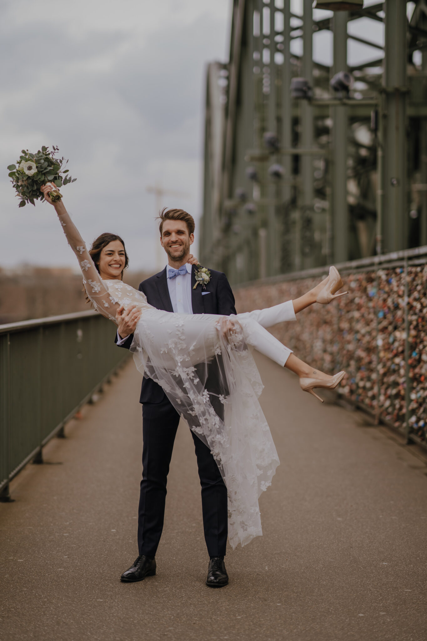 Glückliches Paar auf Hohenzollernbrücke, Liebesschlösser, Brautstrauß