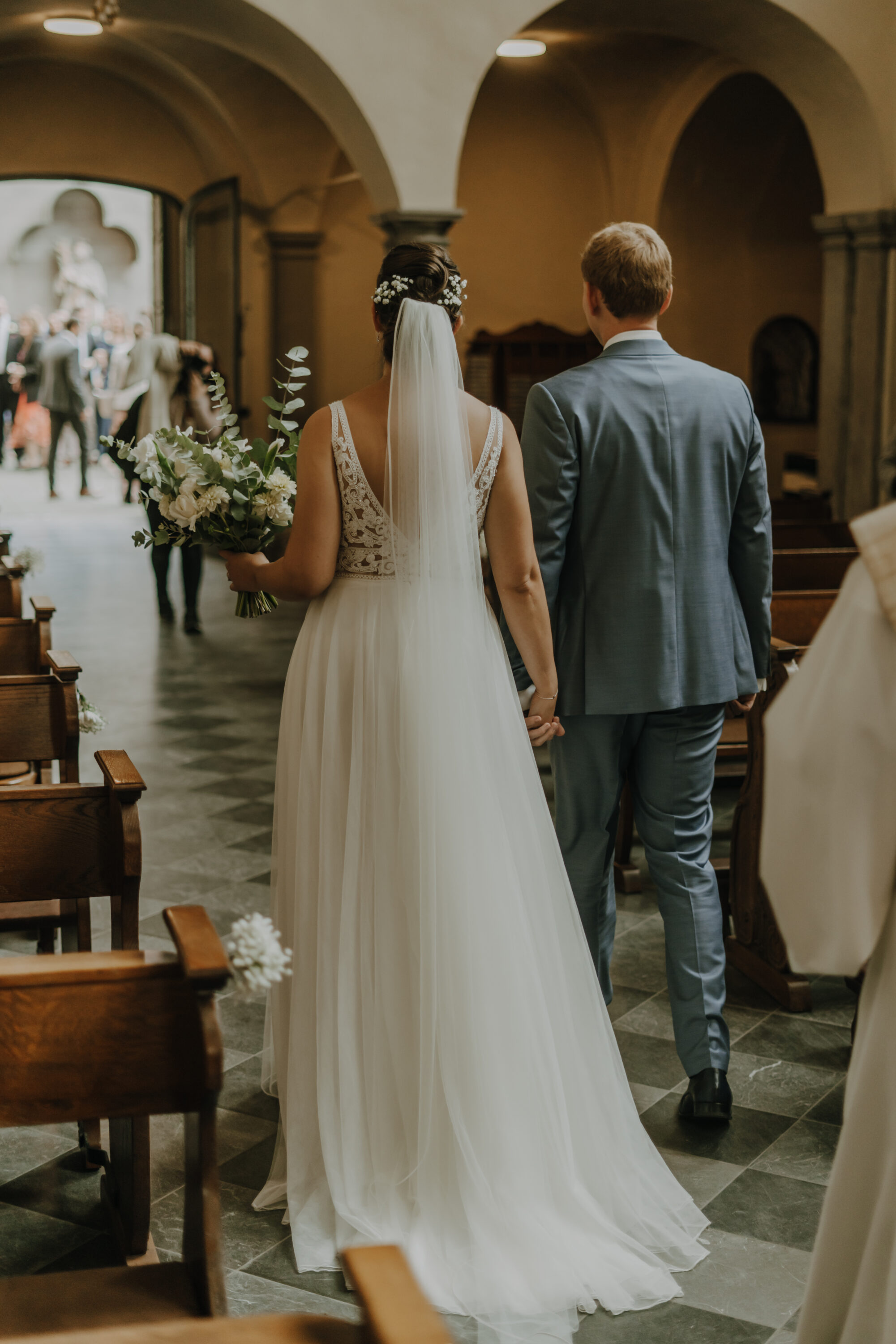Brautpaar verlässt Hand in hand Schlosskirche St. Maria von den Engeln
