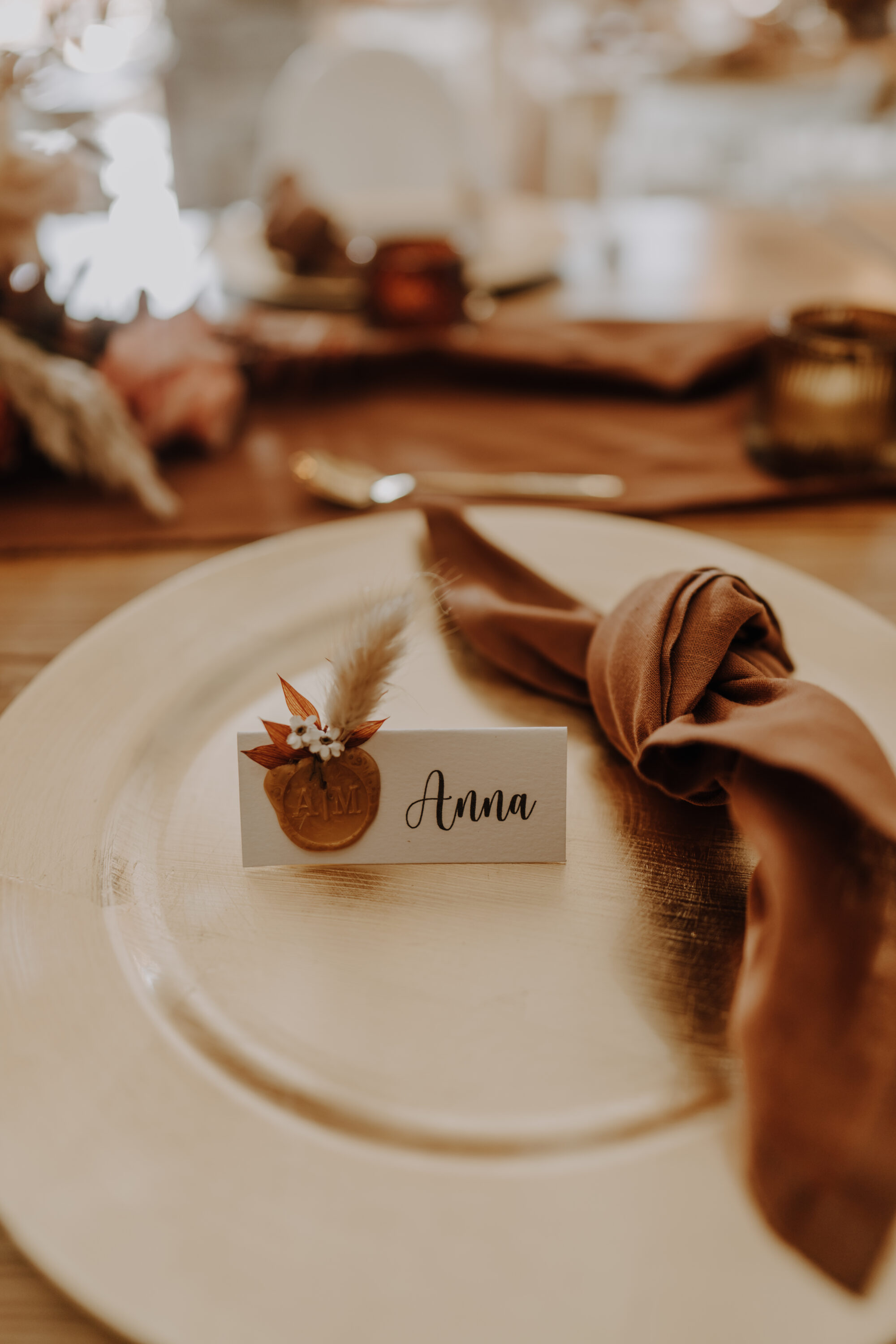 Namensschild der Braut auf geschmücktem Tisch und Teller