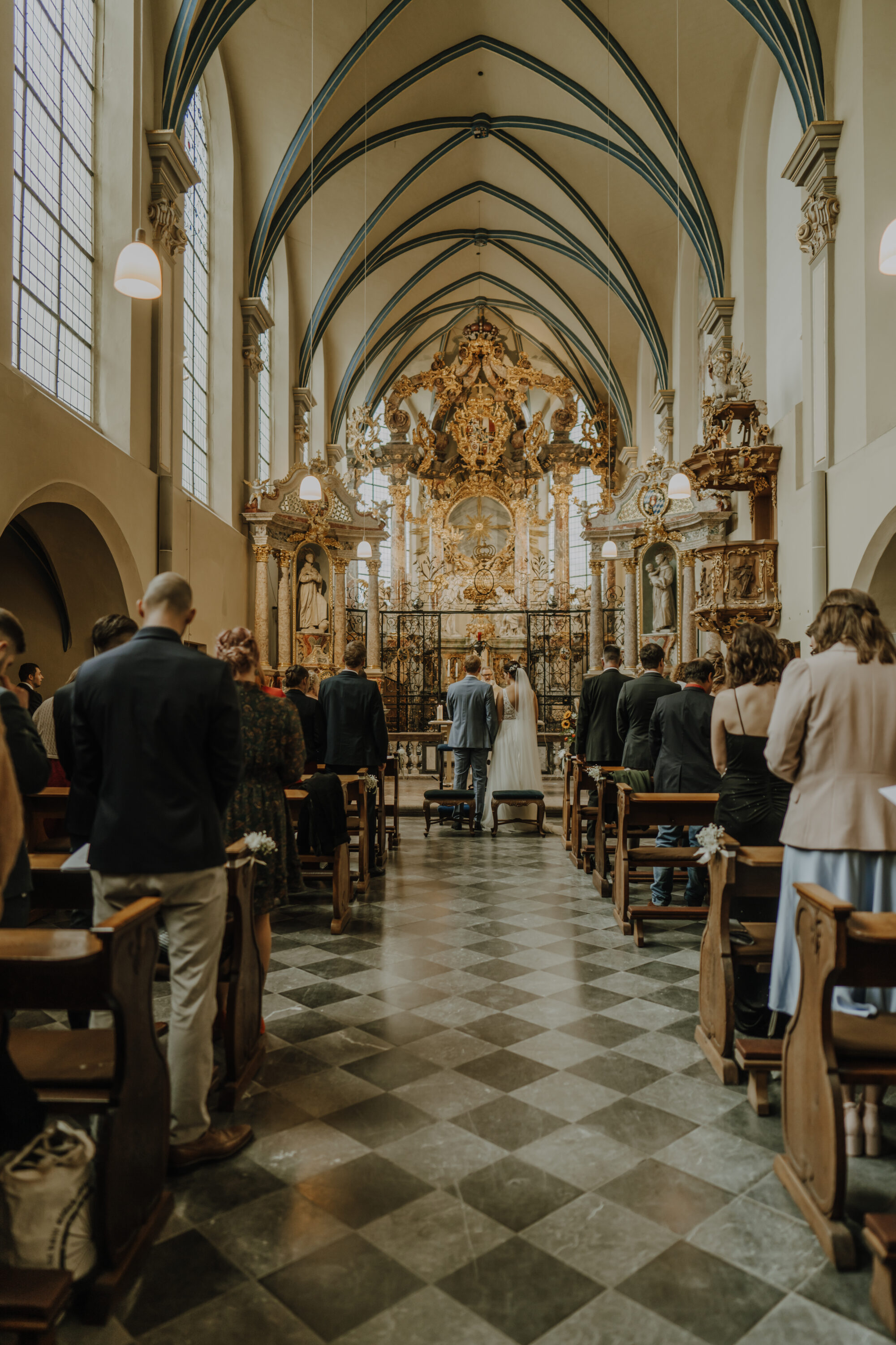 Brautpaar steht am Altar der Schlosskirche St. Maria von den Engeln, hohe Decken