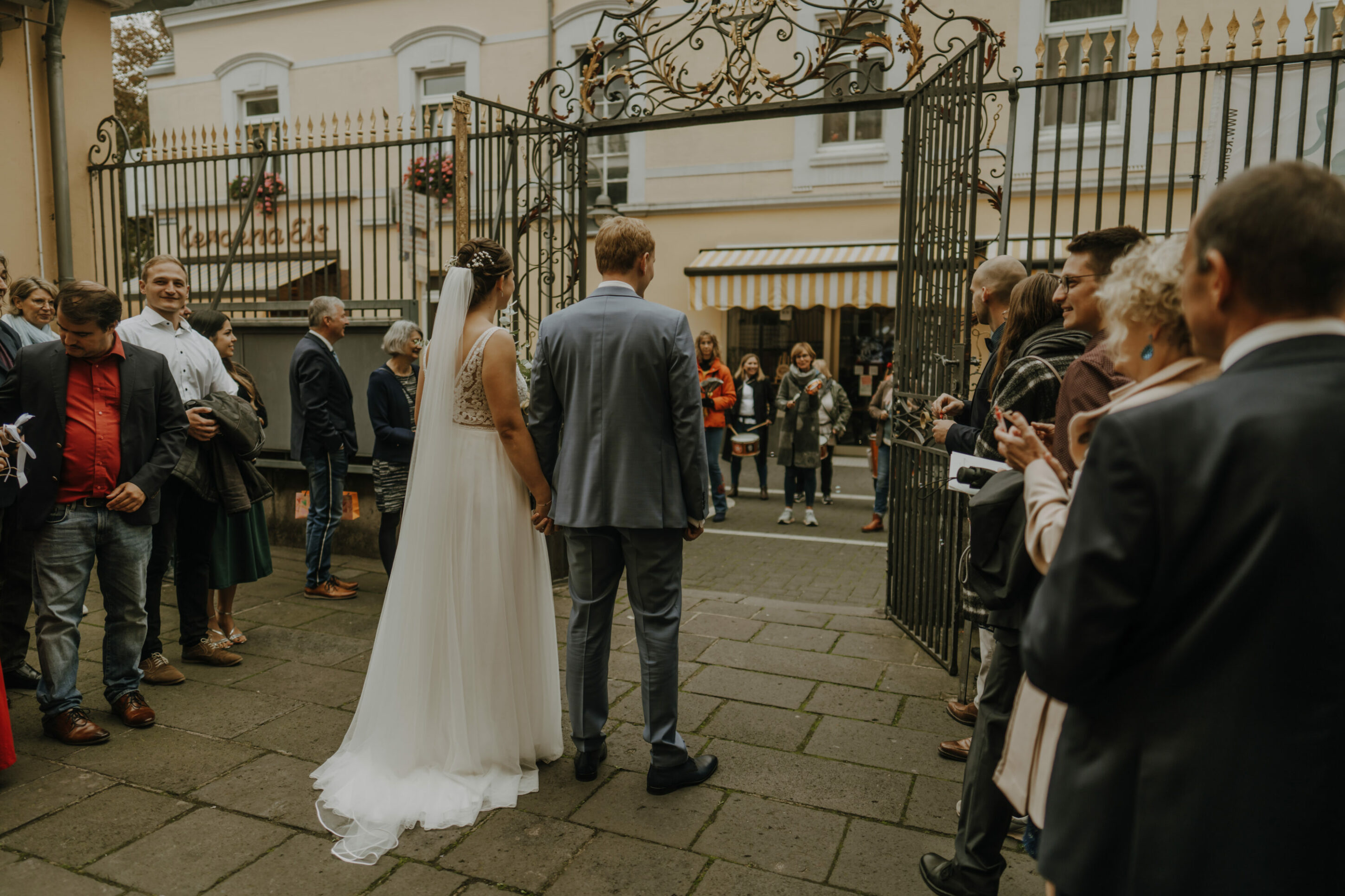 Brautpaar steht vor der Schlosskirche St. Maria von den Engeln mit Hochzeitsgesellschaft
