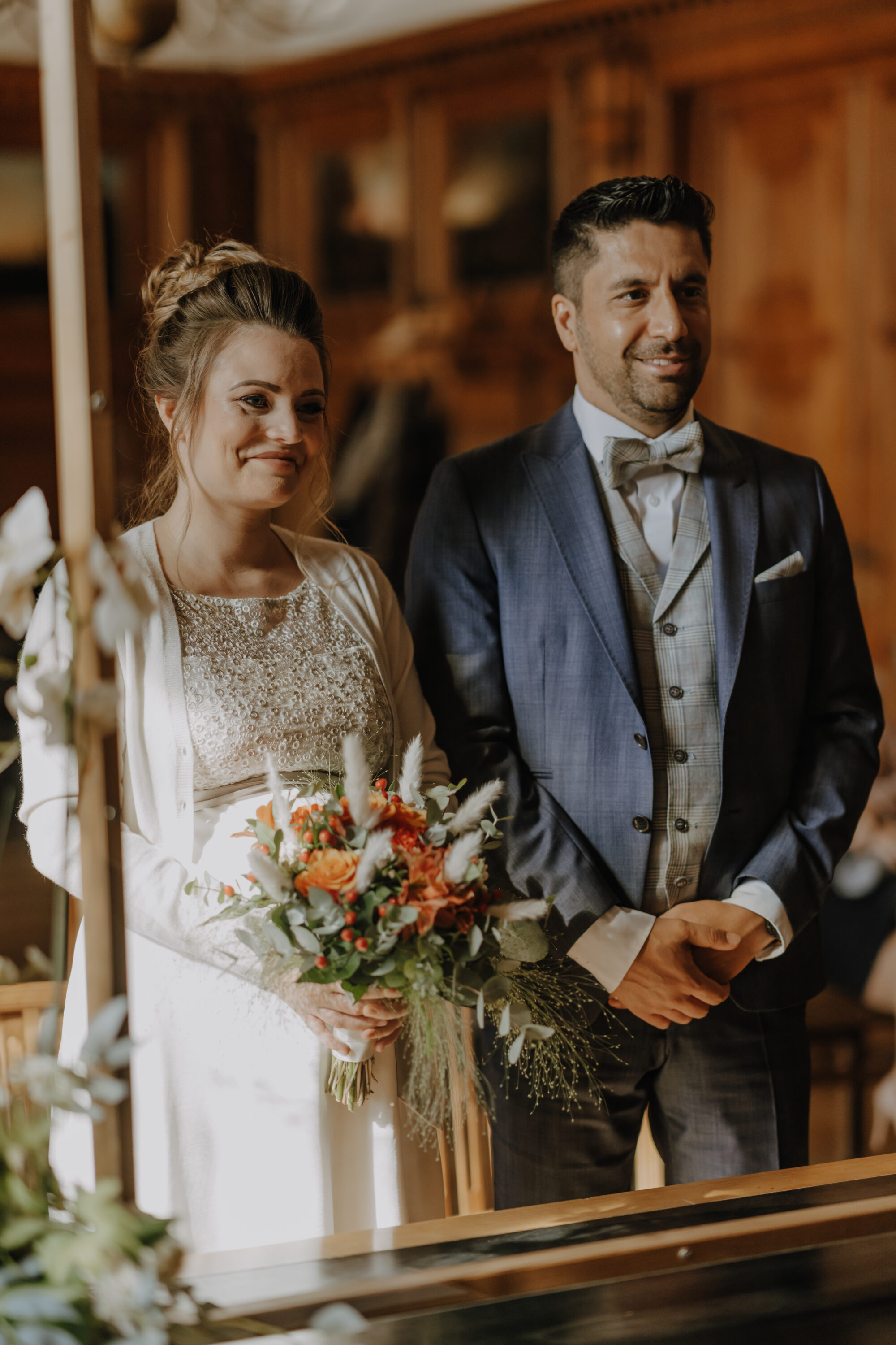 Brautpaar steht am Altar mit Blumenstrauß