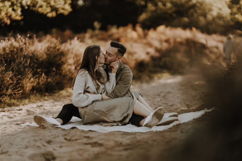 Paar küsst sich auf Decke in Wahner Heide