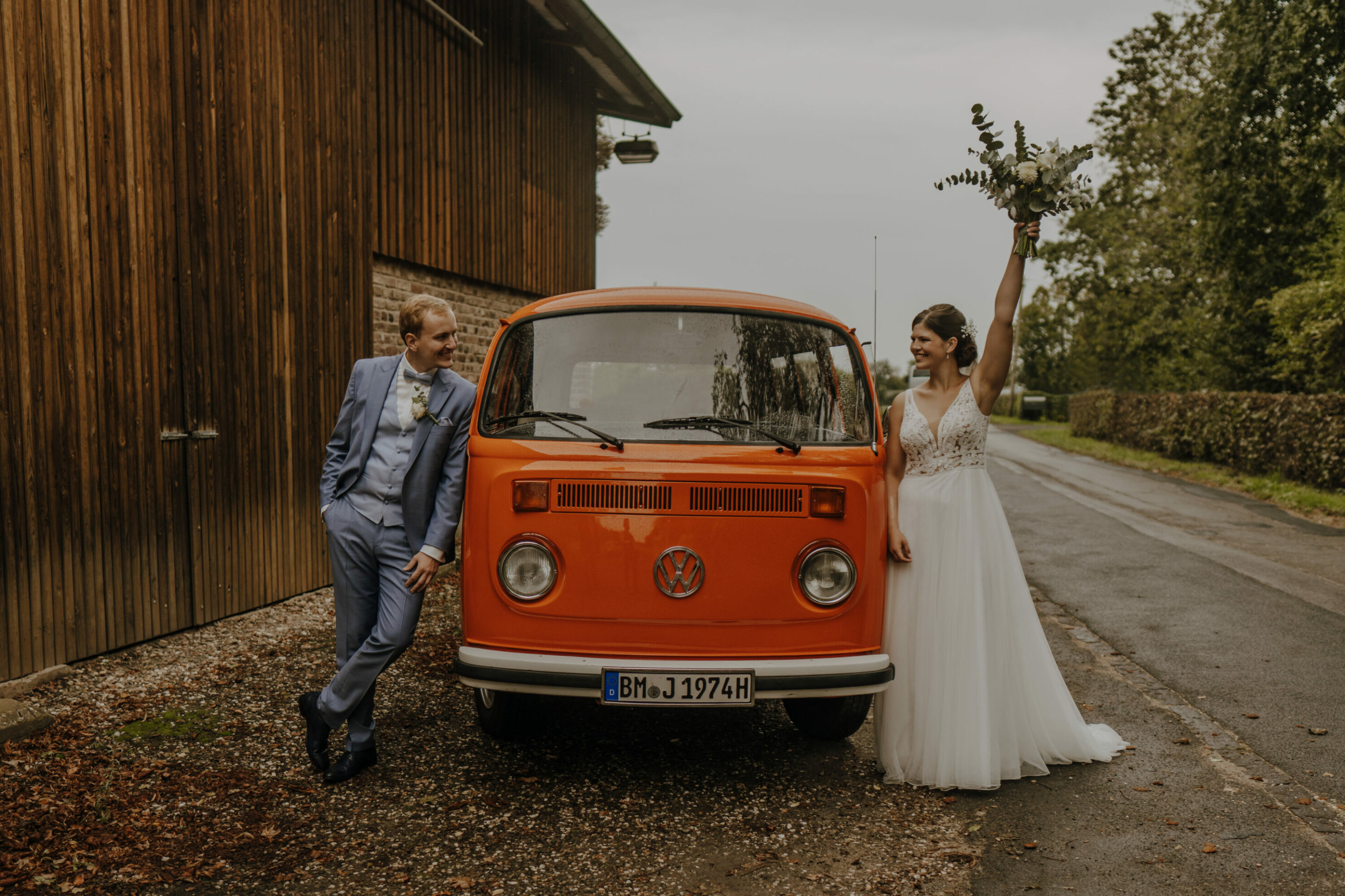 Das Brautpaar mit ihrem Hochzeitsauto, dem Oldtimer VW Bulli