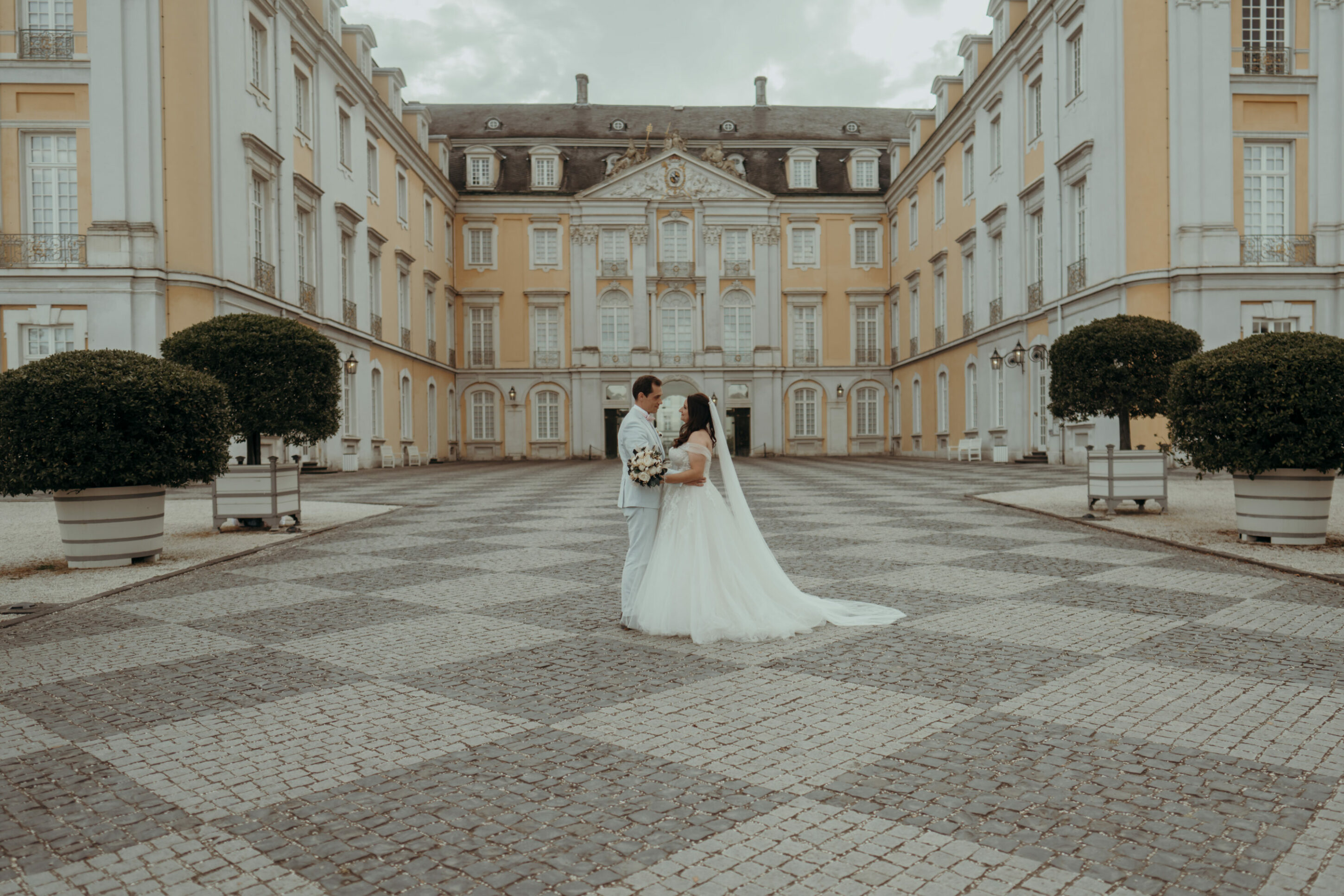 Brautpaar schaut sich tief in die Augen vor Schloss Augustusburg Haupteingang