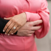 Verlobungsfotos, Umarmung von einem Paar, wo man hinter dem Rücken die Hände mit dem Verlobungsring sieht.