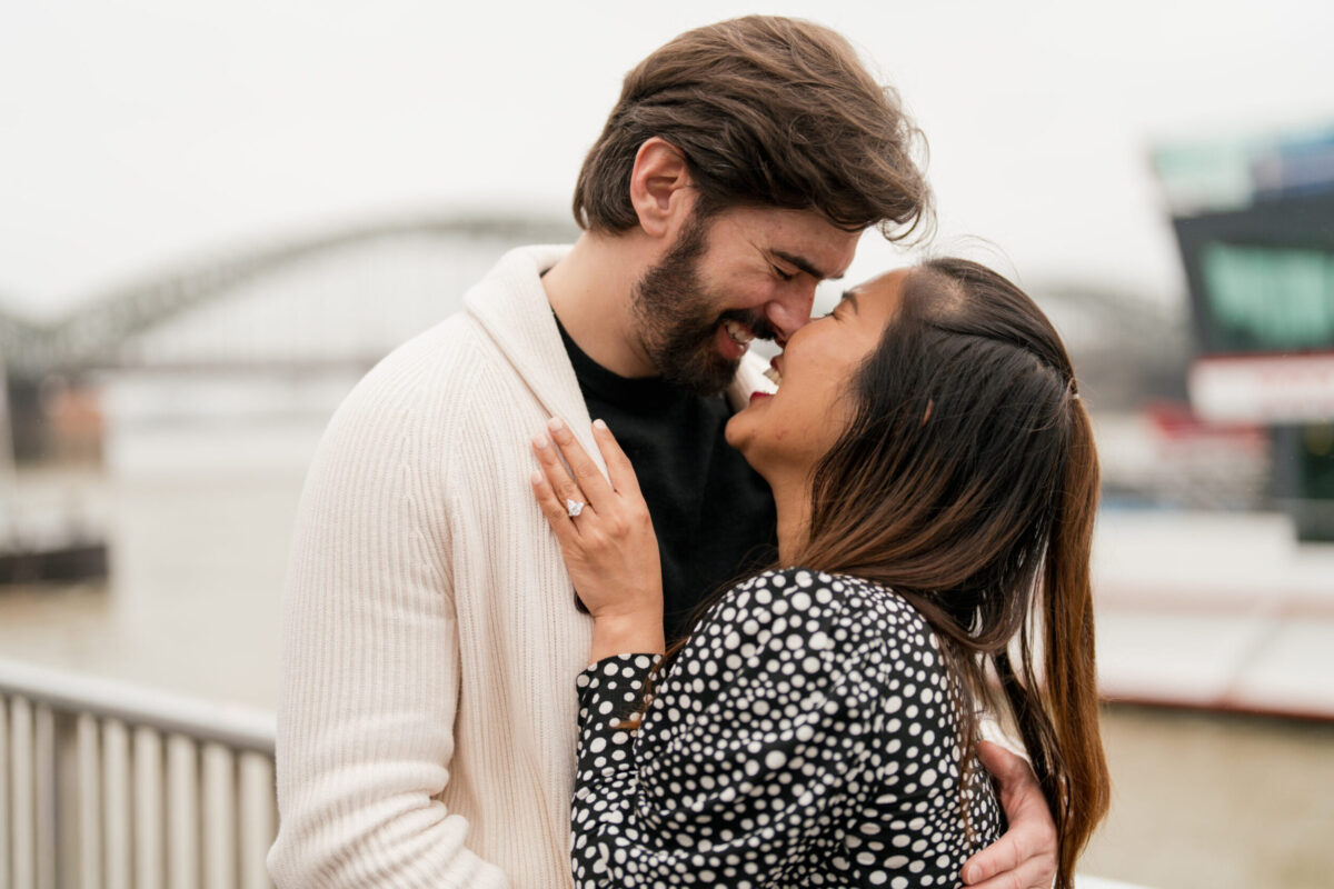 Heiratsantrag Fotoshooting, Paar innig in einer zugewandten Umarmung, mit ihrer Hand auf seiner Brust,, an der der Ring ist.