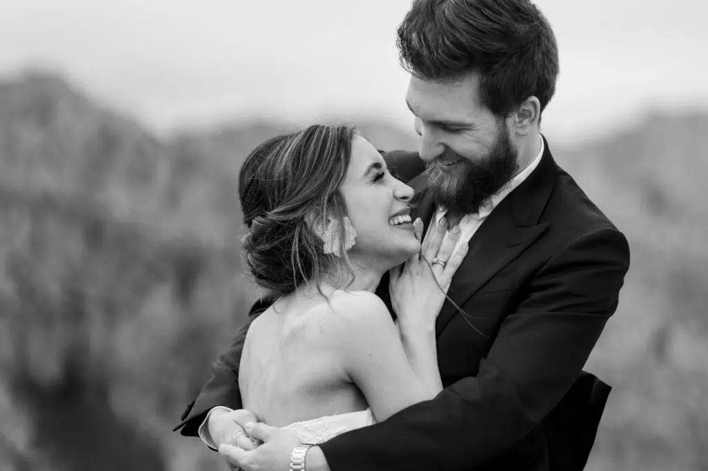 Hochzeitsportfolio, Braut und Bräutigam eng umeinander geschlungen, schauen sich lächelnd an