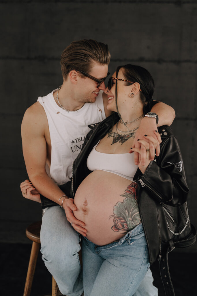 Babybauch Fotografie Portfolio werdendes Elternpaar mit Sonnenbrillen lacht