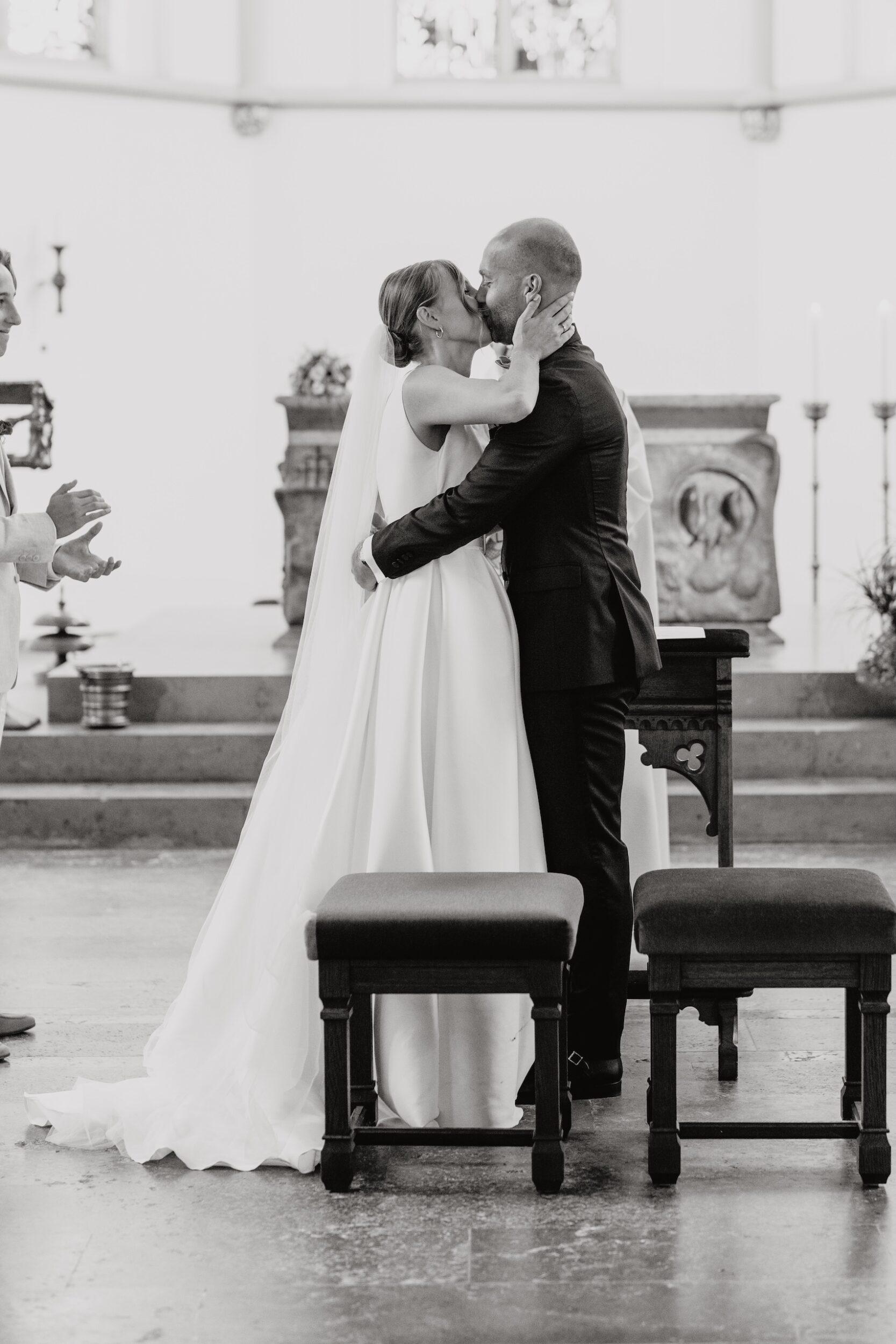 Hochzeitskuss vor dem Altar in der Kirche in Schwarz-Weiß