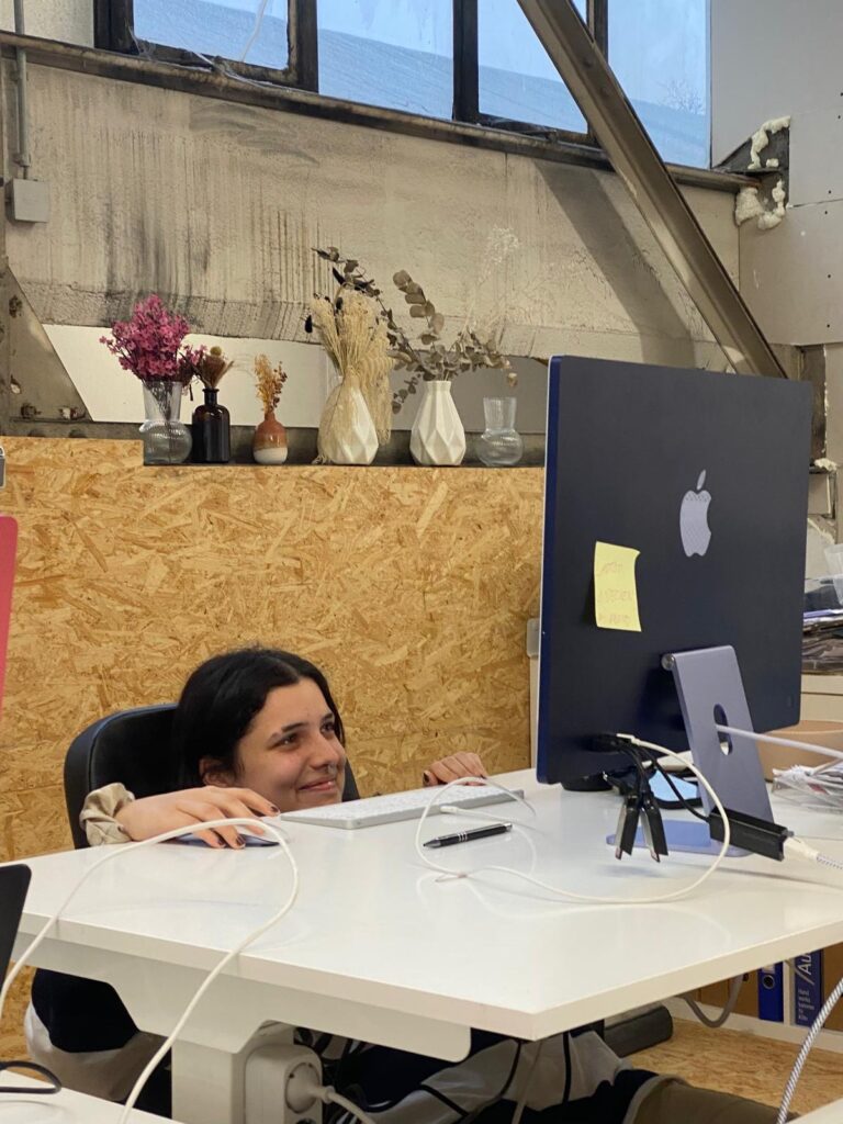 Iman beim Praktikum mit einem sehr weit hochgefahrenen Tisch