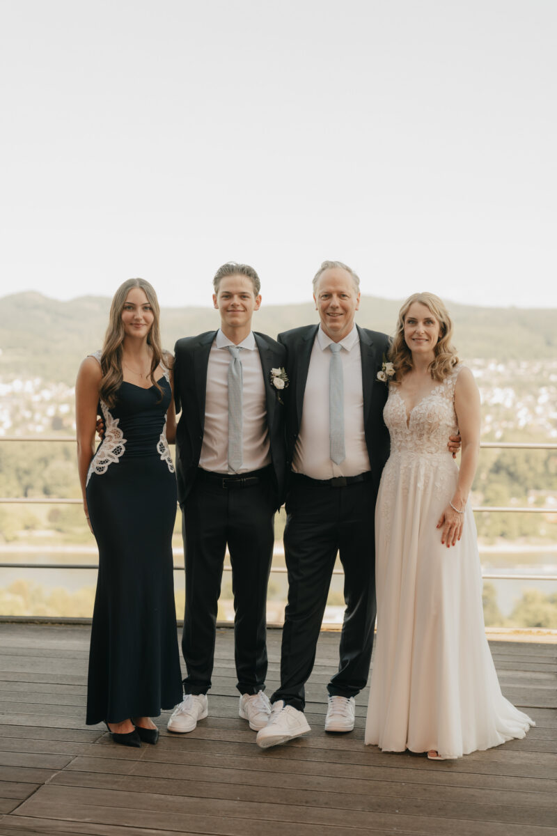 Warmes Familienfoto und im Hintergrund das Rheintal beim Rolandsbogen