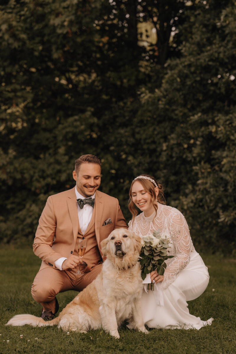 Hochzeitsportfolio, Braut, Bräutigam beide hockend und der Hund vor den beiden