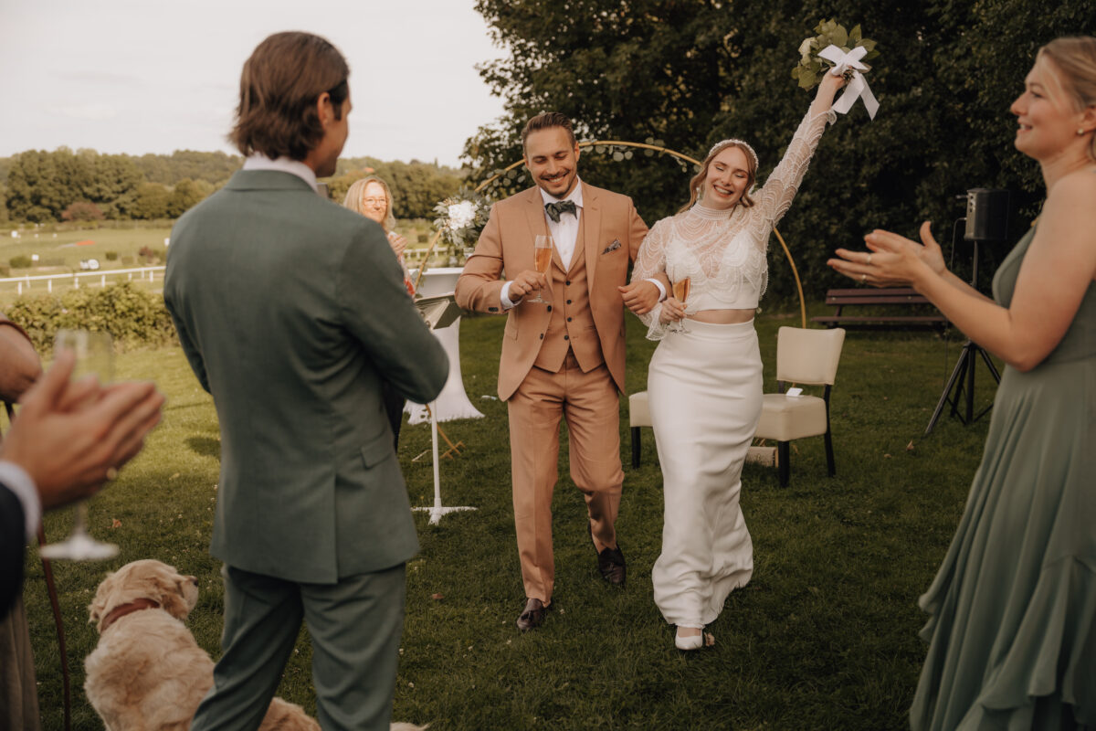 Hochzeitsportfolio, Hochzeitspaar geht glücklich nach der Trauung aus dem Traubereich