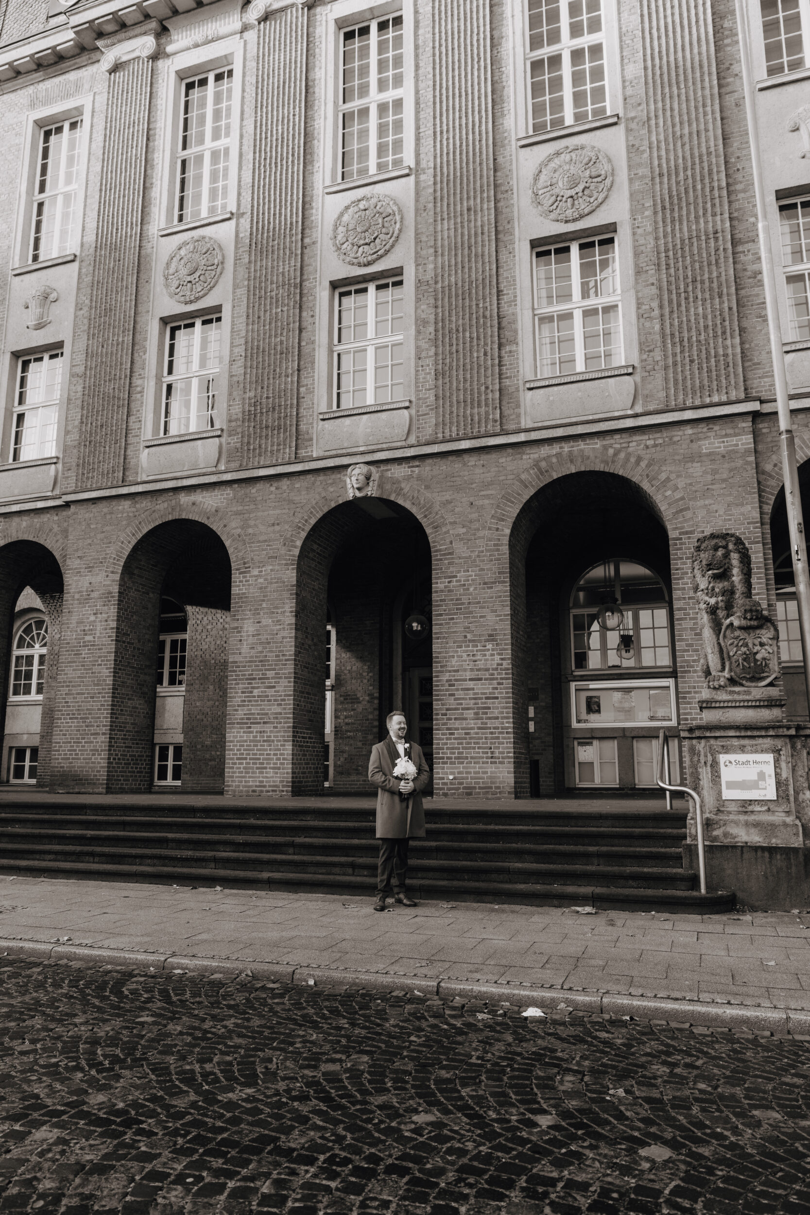 Heiraten im Rathaus Herne: Herzensmomente für die Ewigkeit Christopher steht vor dem Rathaus in Herne