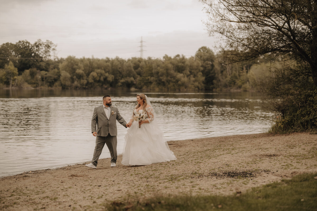 Foto Braut und Bräutigam gehen am Silbersee spazieren - warm Querformat