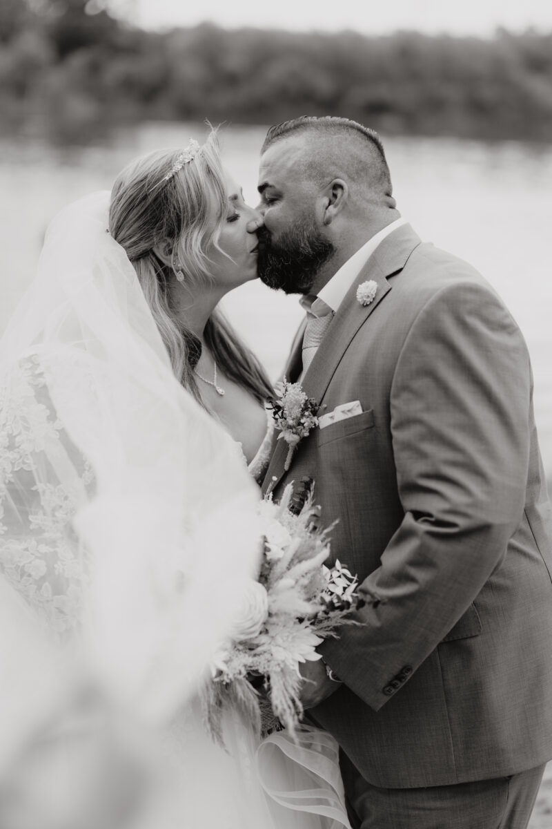 Foto Brautpaar küsst sich halbnah schwarz-weiß Hochformat