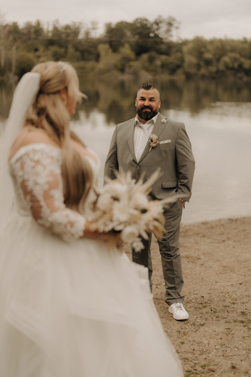Foto Braut vorne unscharf Bräutigam im Hintergrund scharf warm Hochformat