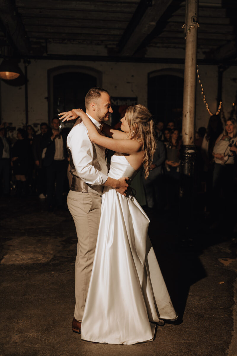 Hochzeitsportfolio, Brautpaar lächeln sich eng umschlungen beim Hochzeitstanz an in der Hochzeitslocation