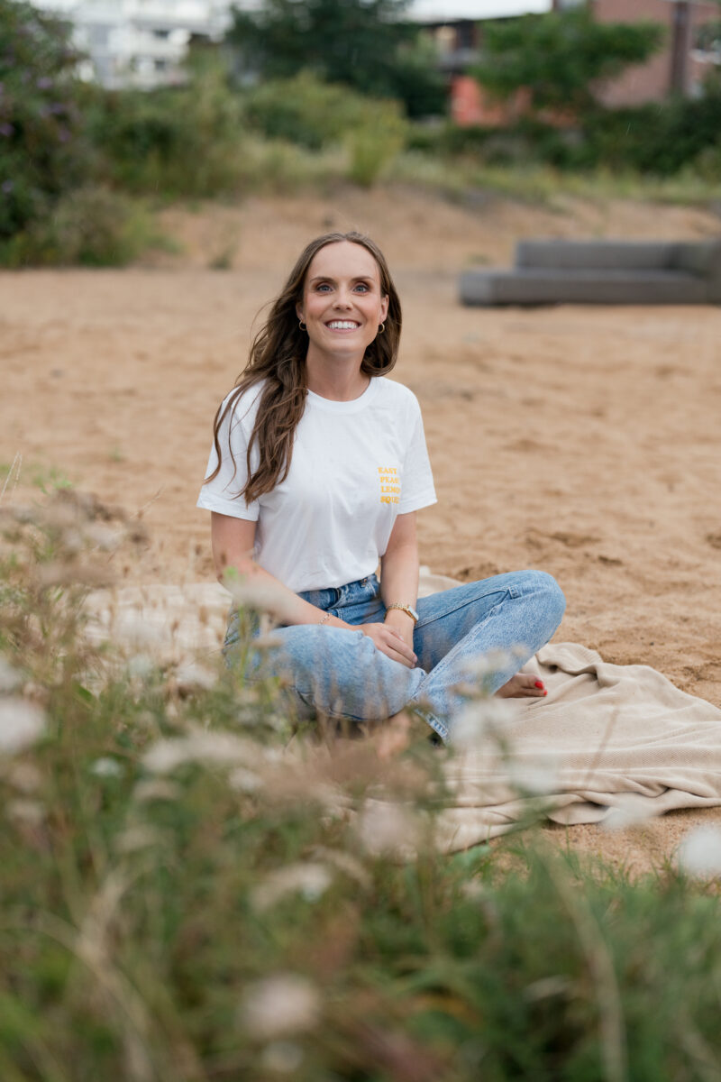 Portraitfoto einer Frau, sitzend auf einer Picknickdecke