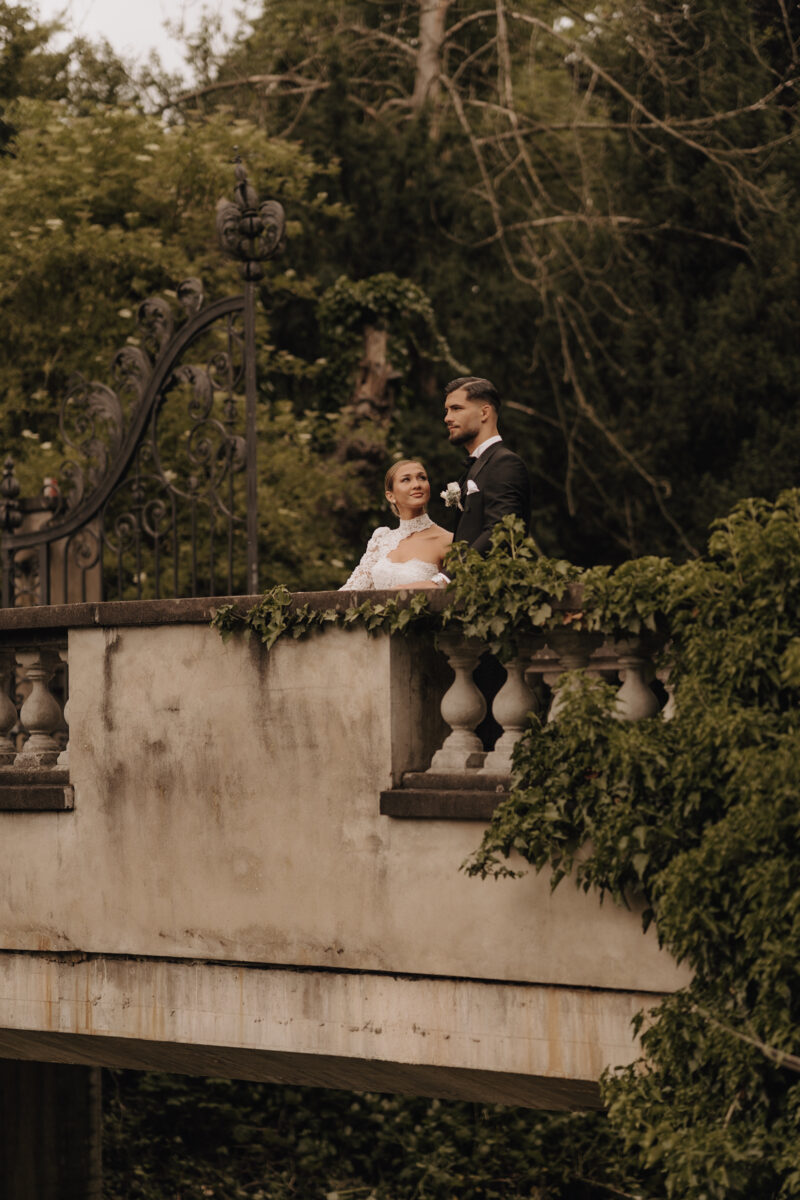 After Wedding Portfolio, Braut und Bräutigam stehen auf einer Brücke und sehen sich verliebt an