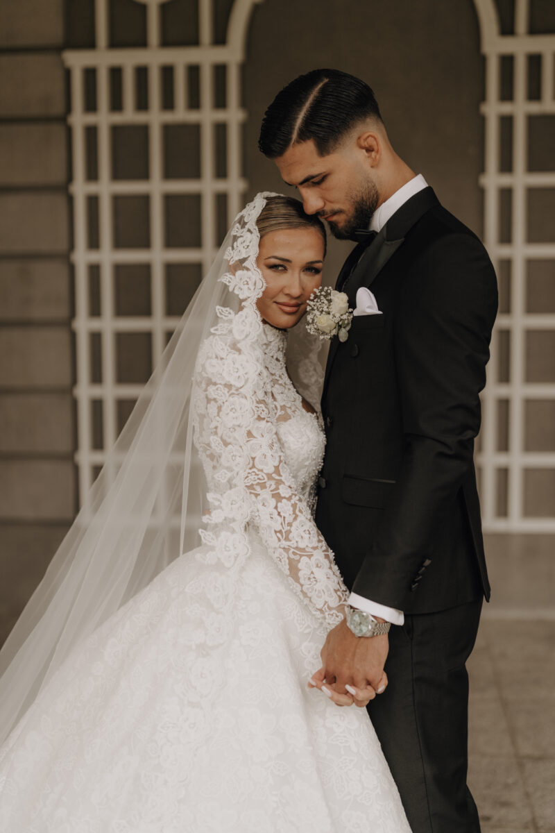 After Wedding Portfolio, Braut und Bräutigam stehen sich gegenüber und halten sich an den Händen, Braut schaut Richtung Kamera