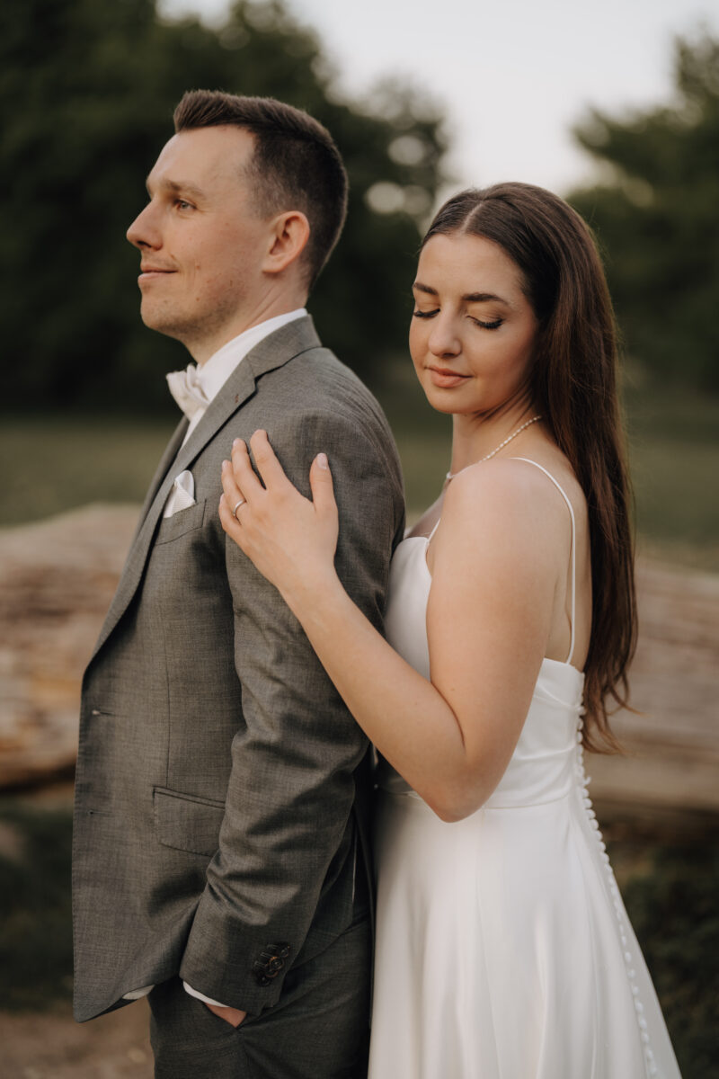 After Wedding Portfolio, Braut steht hinter dem Bräutigam und schaut mit geschlossenen Augen über ihre Schulter, ihr Mann schaut geradeaus