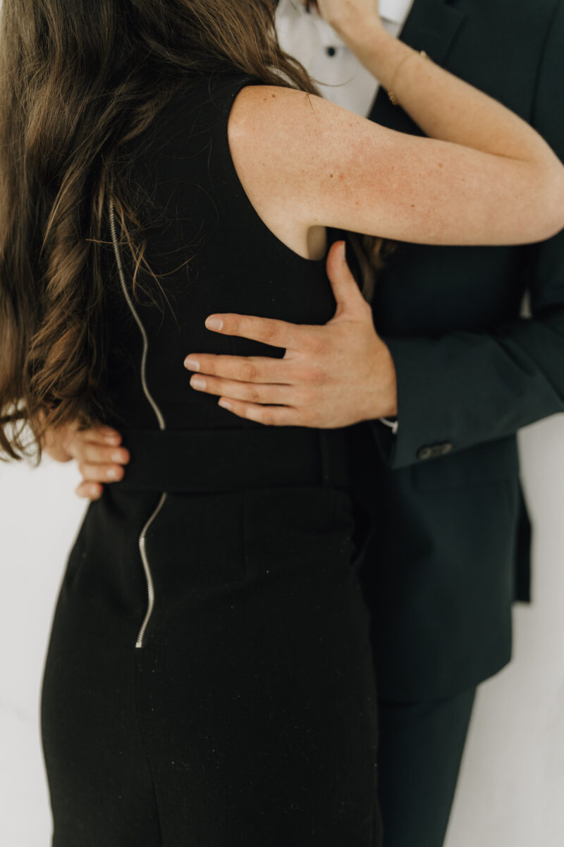 Paar umarmt sich, seine Hand auf ihrer Hüfte liegt im Fokus