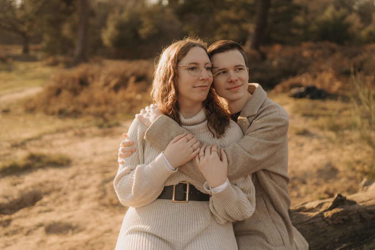 Paar hält sich in den Amen und schauen zusammen in den Sonnenuntergang