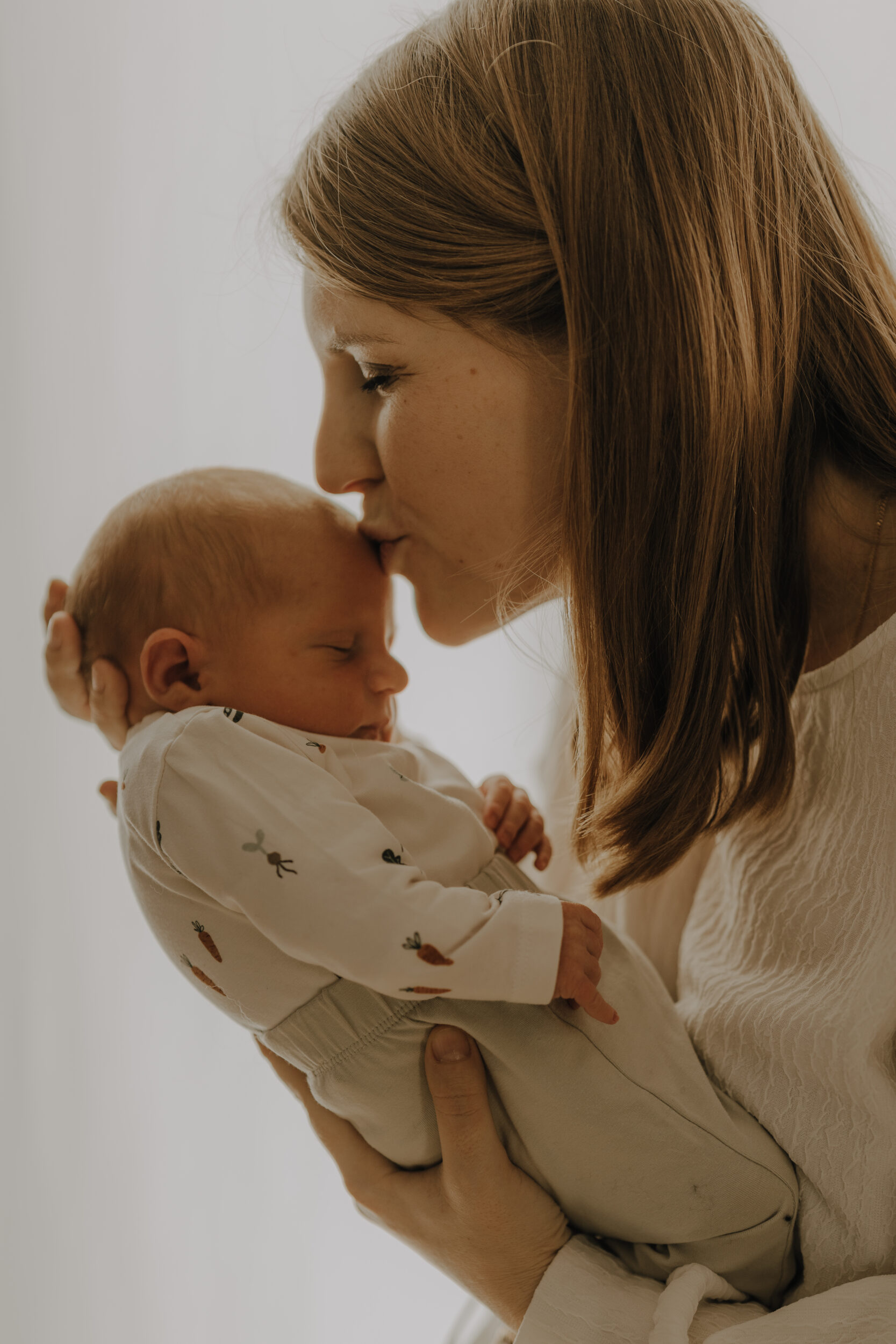 Newborn Portfolio Mama küsst Baby auf Stirn