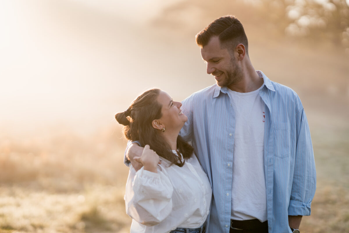 Paar schaut sich lächelnd in die Augen und setzt zum Kuss an