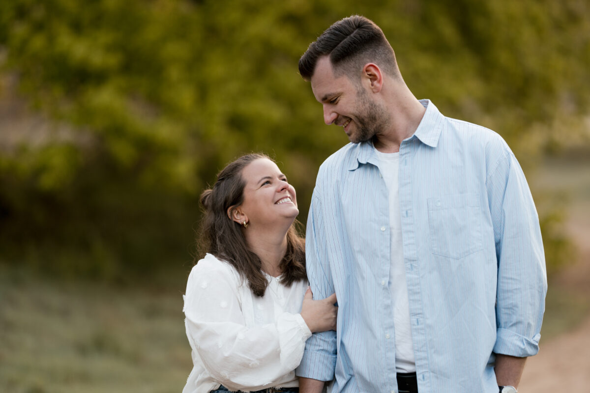 Sie hält sich an seinem Arm fest und lacht