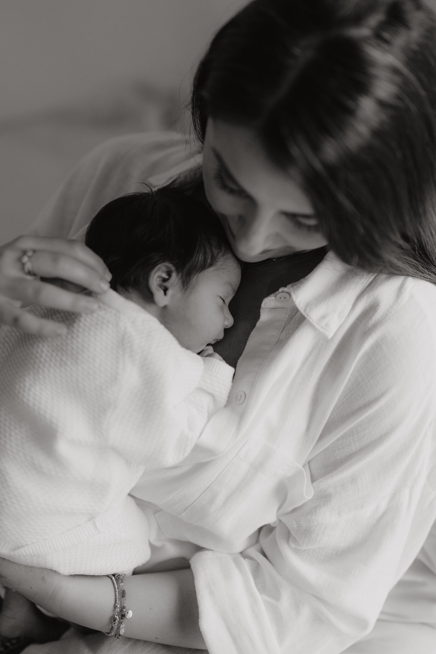 Newborn Portfolio Baby liegt in Mamas Arm schwarz-weiß