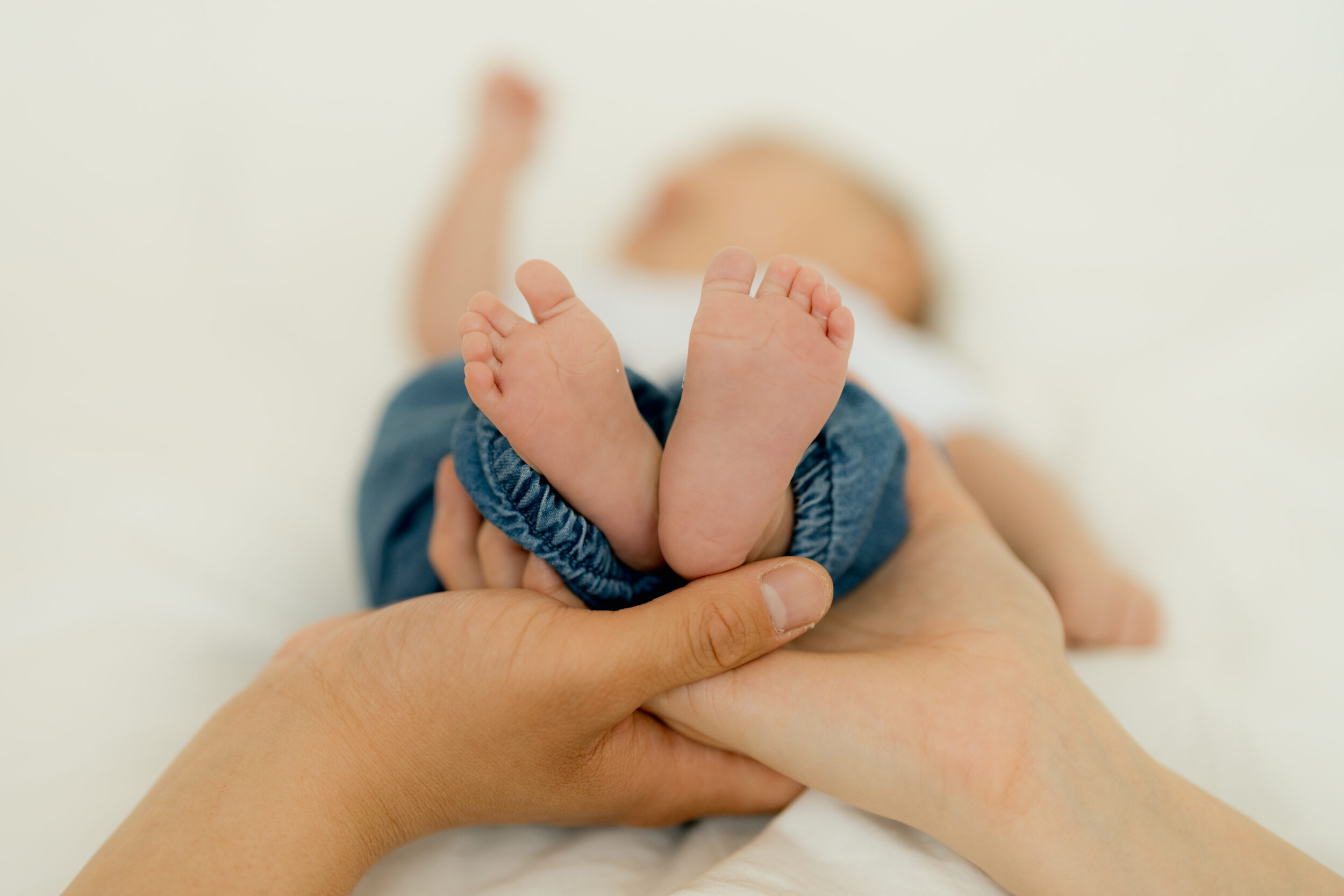 Newborn Portfolio Babyfüßchen wie Herz in Mamas und Papas Hand