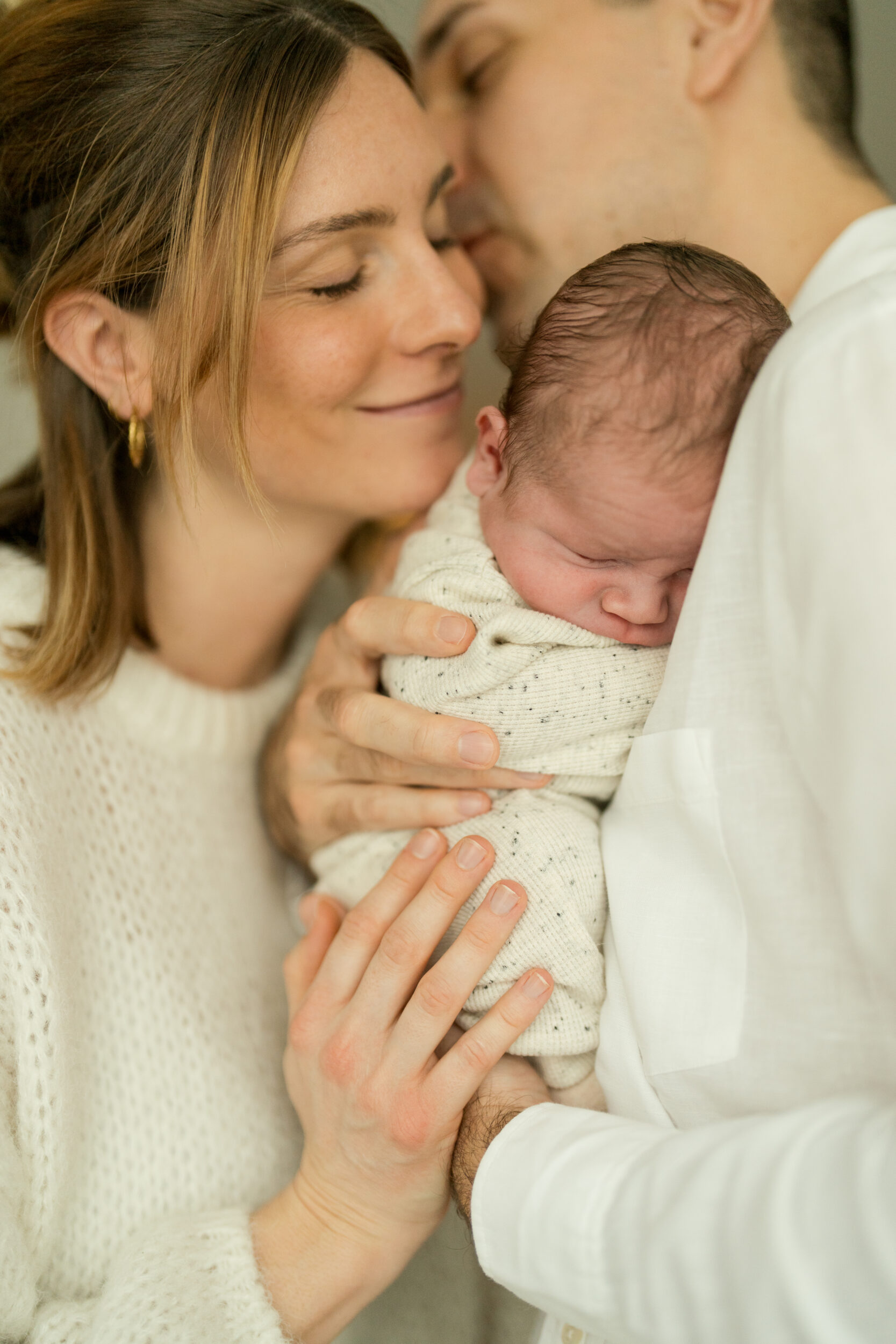 Newborn Portfolio Baby mit Mama an Papas Brust gekuschelt
