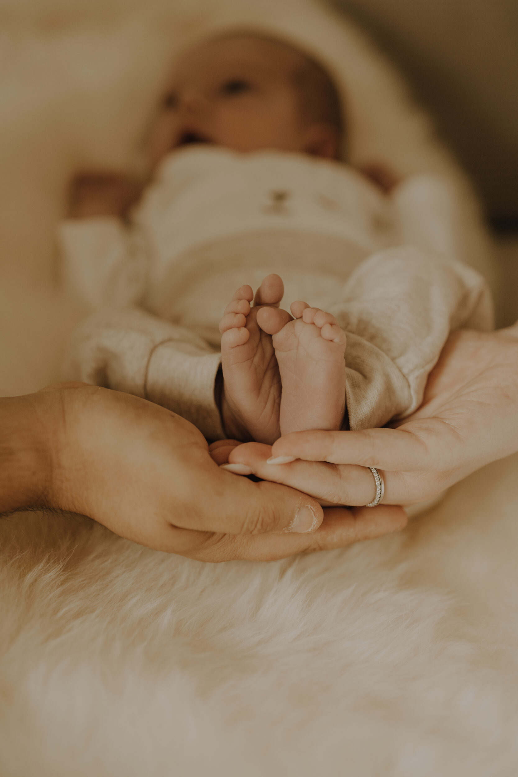 Newborn Portfolio kleine Babyfüßchen in Mamas und Papas Hand