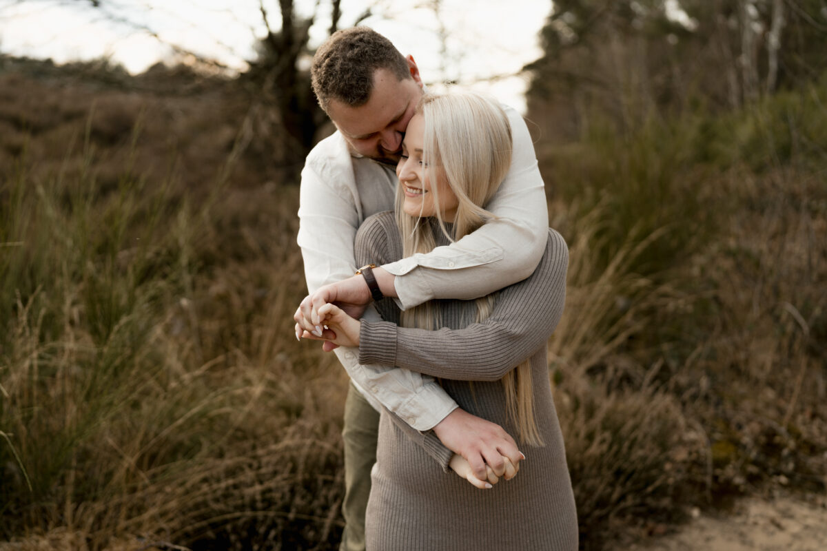 Sie wird von hinten umarmt und lächelt