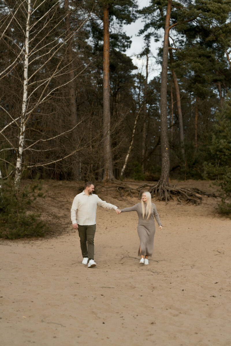 Paar schlendert Händchenhaltend auf die Kamera zu