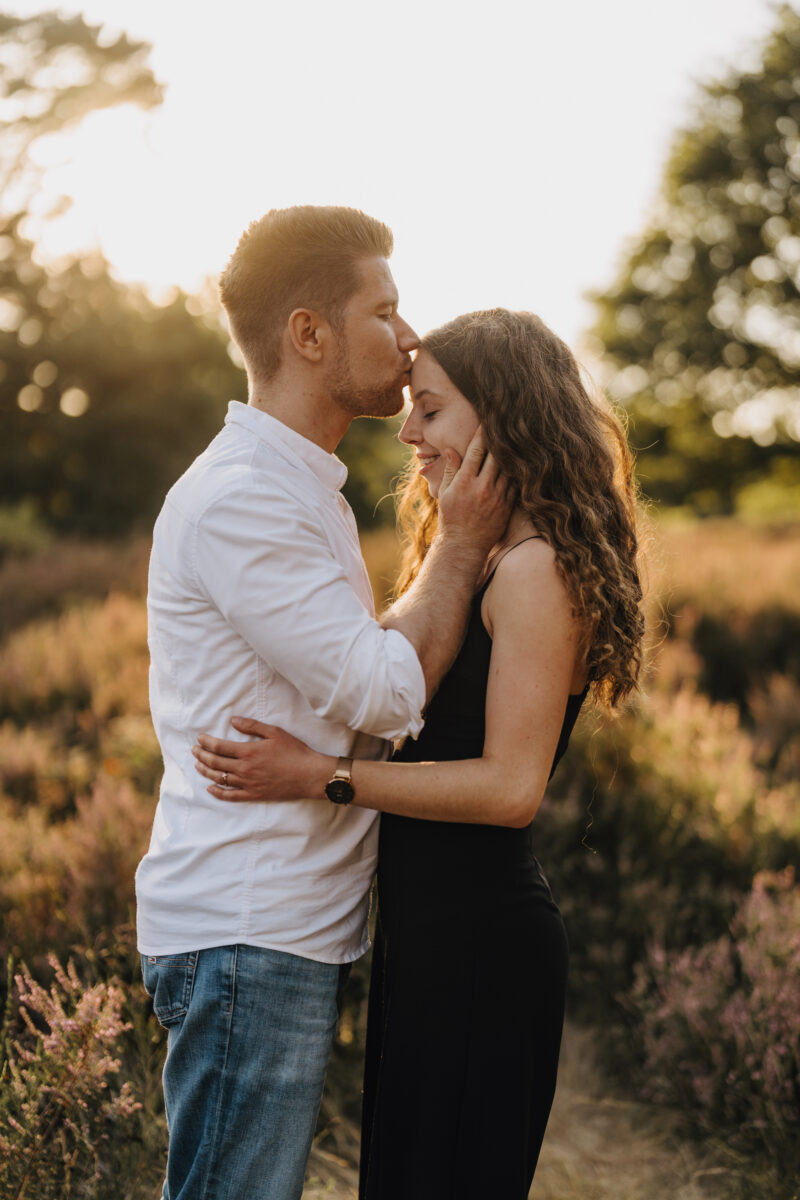 Er gibt ihr einen Stirnkuss im Sonnenuntergang