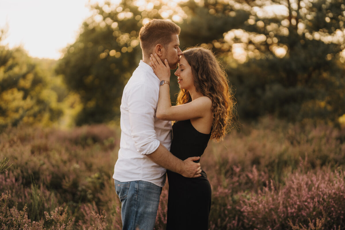 Er küsst Sie auf die Stirn in der Abendsonne